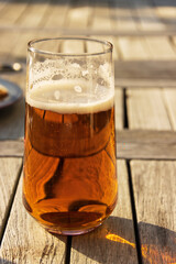 Glass of beer on a wooden outdoor table