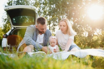 Family in a forest. People by the car. Sunset background.