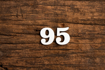 Number 95 in wood, isolated on rustic background