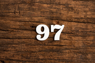 Number 97 in wood, isolated on rustic background - obrazy, fototapety, plakaty