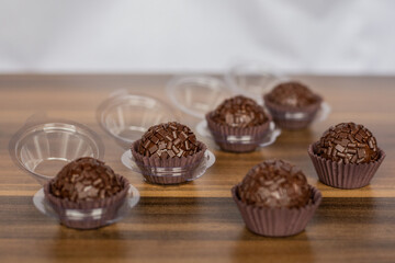 A collection of brigadeiros on a wooden table, traditional Brazilian chocolate sweets