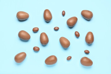 Delicious chocolate eggs on blue background