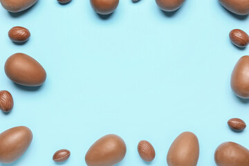 Frame made of delicious chocolate eggs on blue background