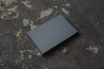 Photo of blank gray business card stack on concrete background.