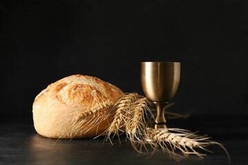 Cup of wine with bread on dark background