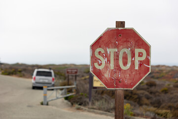 rusty stop sign on a road - obrazy, fototapety, plakaty