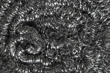 Shiny metallic texture of stainless steel spiral scourer. Abstract macro shot