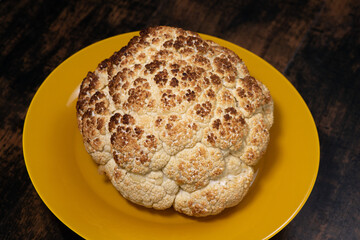 Roasted cauliflower in a yellow plate, turning