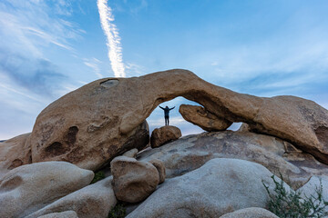 person standing under large rock formation