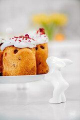 part of decorated panettones on serving plate with rabbits. easter cakes. 