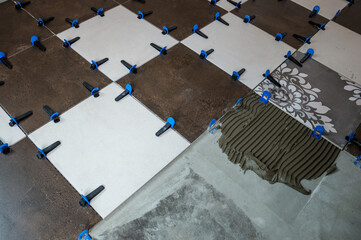 Installing ceramic tiles on the floor with clips and stakes.