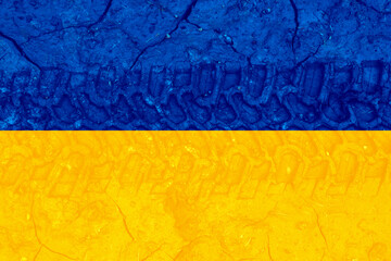 Ukrainian flag with tires track in the wet mud.