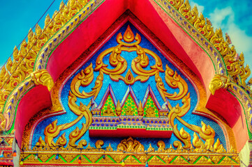 Colourful traditional decorations at Buddhist temple structures in Thailand.