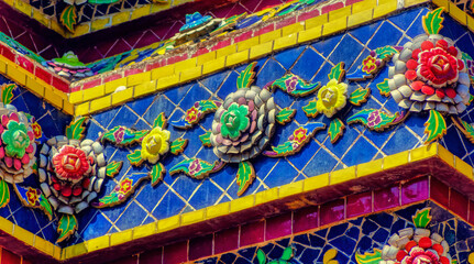 Colourful traditional decorations at Buddhist temple structures in Thailand.
