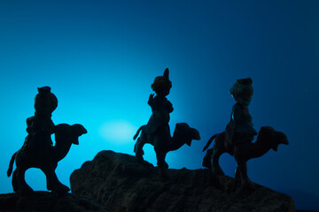 Silhouette of the wise men on their way to Bethlehem with blue copy space