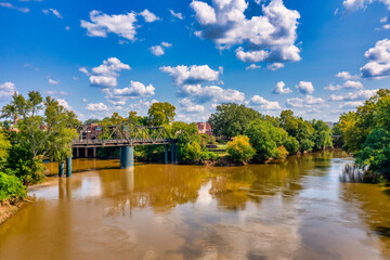 Brown water, trees and clouds River bridge