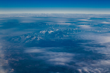 View of the city and mountains from above from a drone and an airplane. Cities aerial view, sky and clouds