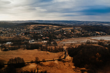 Fototapeta premium View of the city and mountains from above from a drone and an airplane. Cities aerial view, sky and clouds