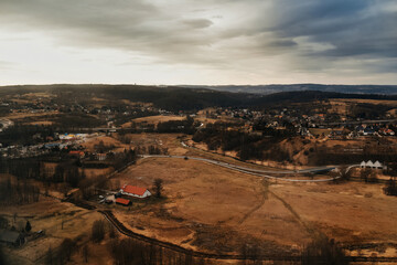 Fototapeta premium View of the city and mountains from above from a drone and an airplane. Cities aerial view, sky and clouds