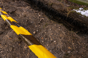 Red and white barrier tape protect a danger place. The warning tape indicates the danger of being...