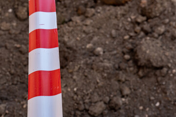 Red and white barrier tape protect a danger place. The warning tape indicates the danger of being...