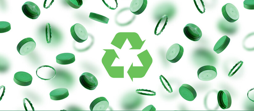 Green bottle caps for recycling symbol on white background. Plastic caps floating, fly. The concept of safety from environmental damage. The idea of environmental sustainability and Earth Day. Banner