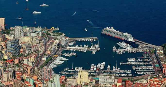 Aerial view of port Hercules of Monaco at sunset, Monte-Carlo, huge cruise ship is moored in marina, view of city life from La Turbie mountain, a lot of mega yachts and boats