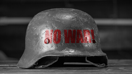 Black and white photo of metal military helmet with the inscription No war on black background. NO...