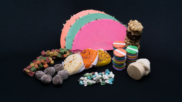 Coloridos y festivos dulces t&iacute;picos mexicanos en fondo negro, palanquetas, tamarindo, bombones, chocolate dulces, mazapan, cacahuates.  