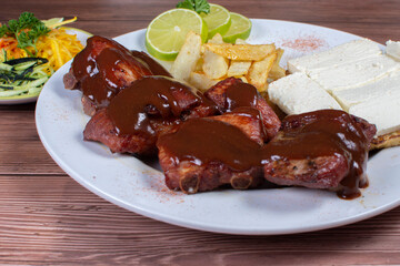 Traditional Colombian food, grilled ribs with bbq sauce, chocolo arepa with cheese, salad, french fries and salad