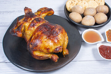 Roast chicken, traditional Colombian food, accompanied by boiled potato, arepa, sauces
