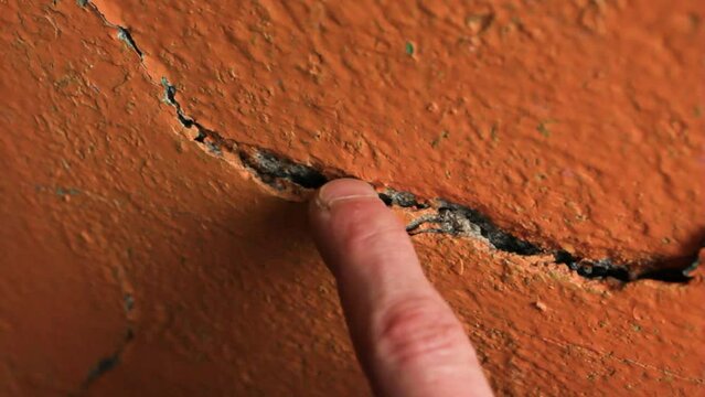 Crack in the wall close-up. Cracked wall plaster and paint.