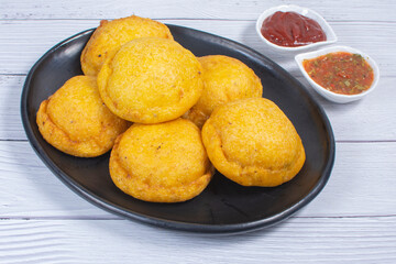 Traditional Colombian snack, chicken empanada with hogao, lemon and sauce