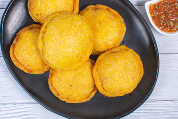 Traditional Colombian snack, chicken empanada with hogao, lemon and sauce