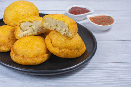Traditional Colombian snack, chicken empanada with hogao, lemon and sauce