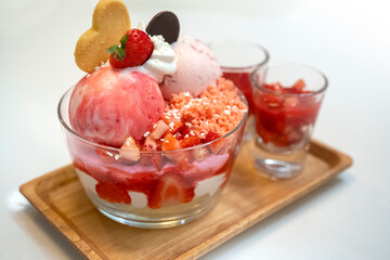 Bowl of pink strawberry ice cream and fresh strawberry.