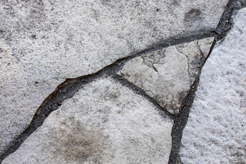 Cracks in flagstone create an abstract pattern.