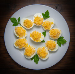 Stuffed eggs with crab crumbs, mayonnaise and parsley macro on a plate