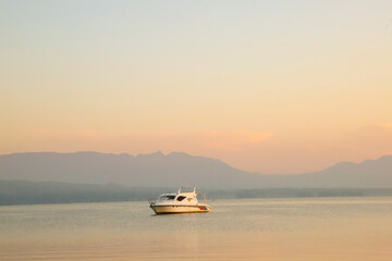 Naklejka premium Lake Toba Background with Ship at sunrise with golden clouds