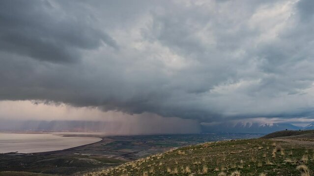 Rain storm moving over Utah Valley with thick dark clouds in timelapse during Spring thunderstorm.