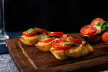 Typical Italian bruschetta or Spanish tapa with cherry tomato, basil and Philadelphia type spreadable cheese. Mediterranean food concept.