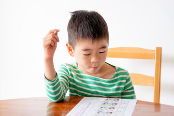 Naklejka premium Little asian boy studying at home