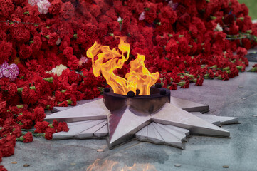 May 9, Victory Day, holiday background. Carnations, eternal flame, a monument - a symbol of May 9,...