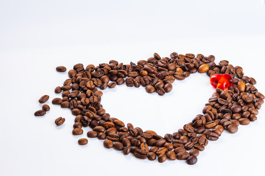 Heart from coffee beans. crystal red heart inside heart made of coffee beans on white background.
