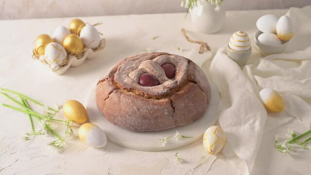 Portuguese traditional Easter cake. Folar with eggs on easter table. Blossom flowers and colorful painted eggs