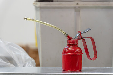 red metal oil can filled with oil and lubricant