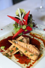 Bonito fish with sauce on the restaurant table.