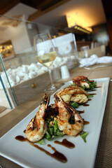 Shrimp and vegetables with white wine in the dinner plate.