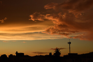 Multicolored sunset in the city, sky and clouds in shades of purple, lilac, red, lilac, aquamarine.