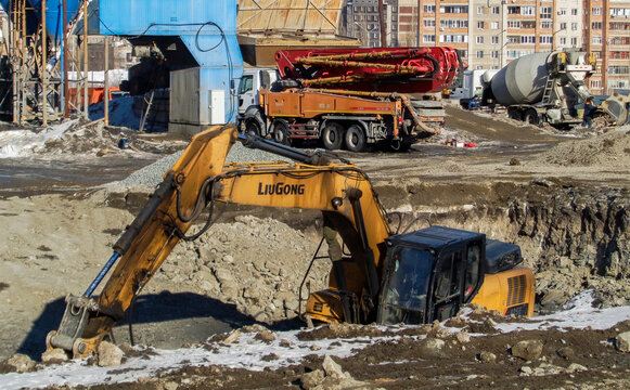 kazakhstan, Ust-Kamenogorsk, february 15, 2021: Construction site. Trucks and excavator. Earthworks. New residentential area. Industrial background. Winter